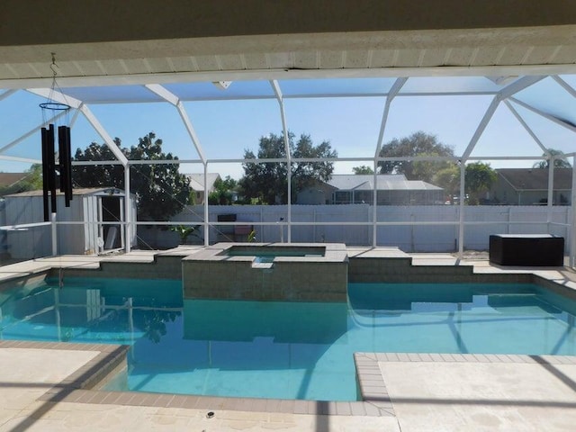 view of swimming pool with glass enclosure, an in ground hot tub, and a patio