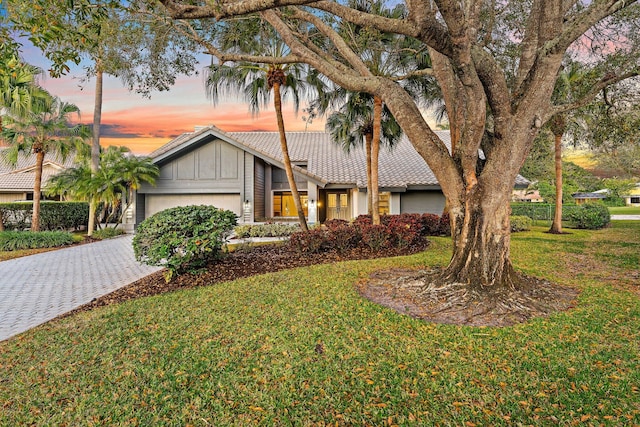 view of front of house featuring a garage and a lawn