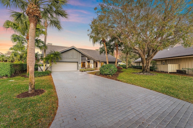 view of front of property with a garage and a lawn