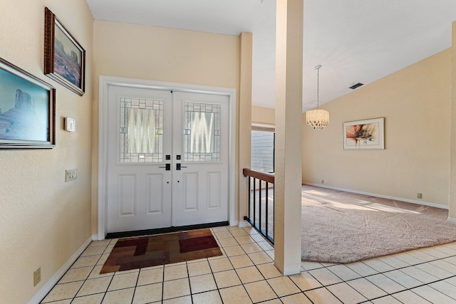 carpeted foyer featuring vaulted ceiling and a notable chandelier