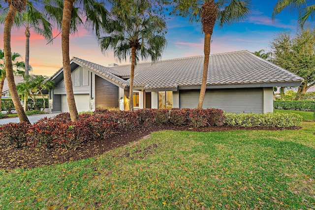 view of front of property with a garage and a lawn