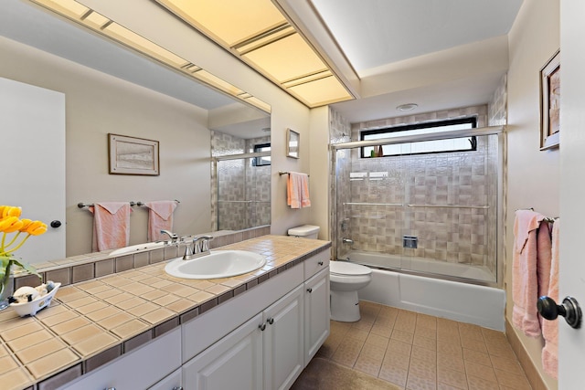 full bathroom with vanity, tile patterned flooring, toilet, and combined bath / shower with glass door