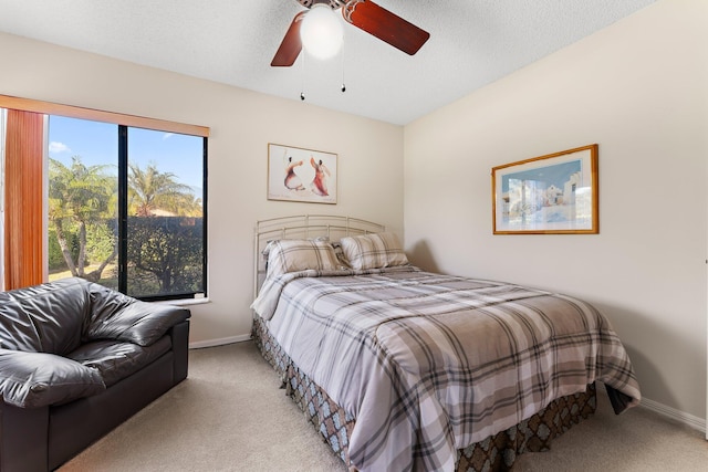 bedroom with light carpet, ceiling fan, and a textured ceiling