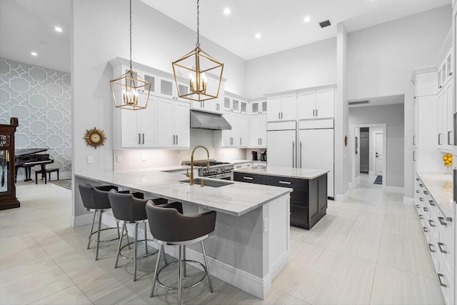 kitchen with a high ceiling, hanging light fixtures, a kitchen breakfast bar, and sink