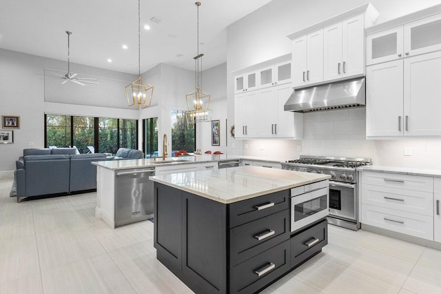 kitchen with white cabinetry, a kitchen island, hanging light fixtures, and appliances with stainless steel finishes