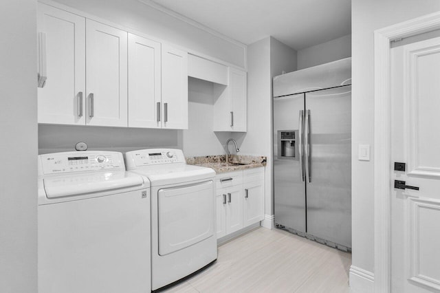 laundry room with cabinets, sink, and washing machine and clothes dryer