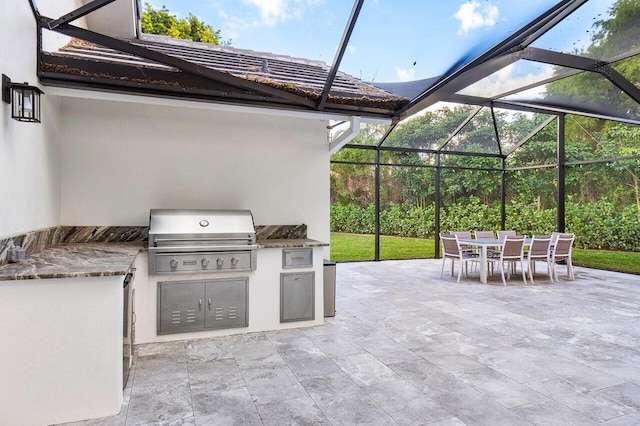 view of patio with a lanai, area for grilling, and exterior kitchen