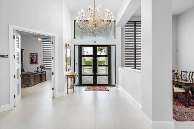 entrance foyer featuring french doors, ceiling fan with notable chandelier, and a high ceiling