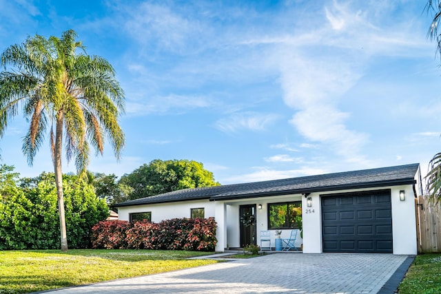 ranch-style home featuring a front lawn and a garage