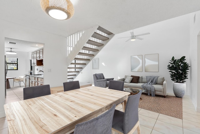 tiled dining room with ceiling fan, sink, a textured ceiling, and a wealth of natural light