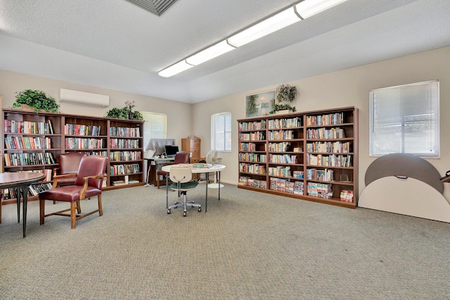 carpeted office space featuring an AC wall unit and a textured ceiling