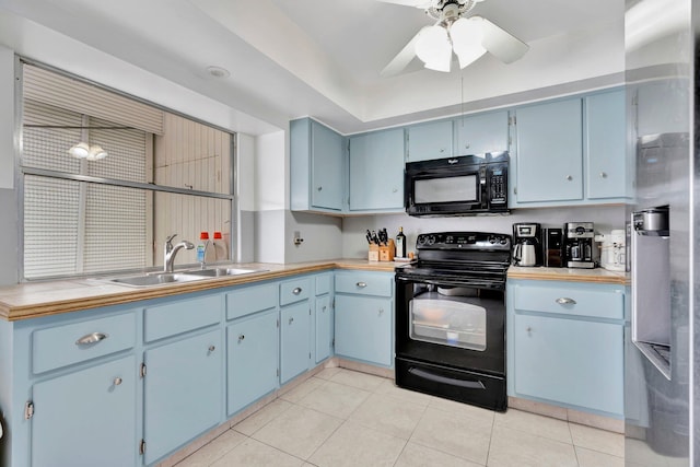 kitchen featuring ceiling fan, sink, blue cabinets, light tile patterned flooring, and black appliances