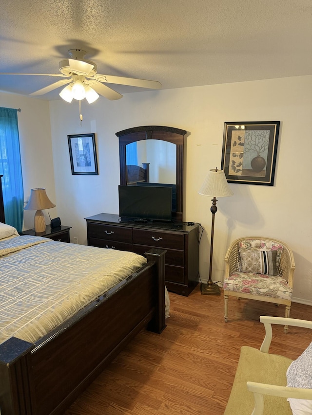 bedroom featuring ceiling fan, a textured ceiling, and hardwood / wood-style flooring