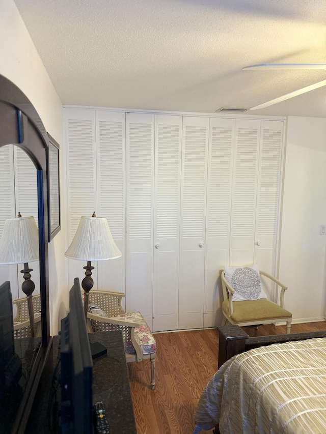 bedroom featuring hardwood / wood-style flooring, a textured ceiling, and a closet