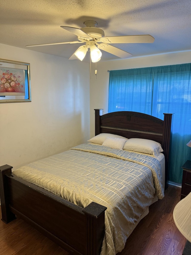 bedroom featuring ceiling fan, dark hardwood / wood-style flooring, and a textured ceiling