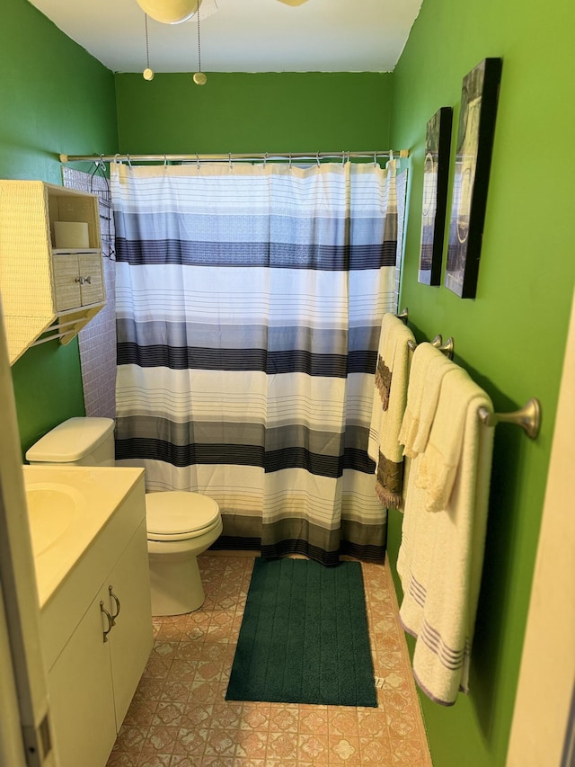 bathroom featuring vanity, toilet, and curtained shower