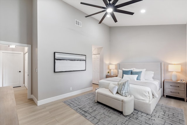 bedroom featuring high vaulted ceiling, light hardwood / wood-style flooring, and ceiling fan