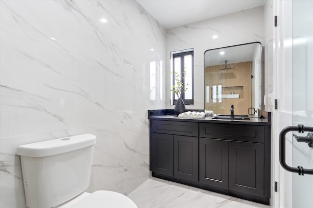 bathroom with an enclosed shower, vanity, toilet, and tile walls