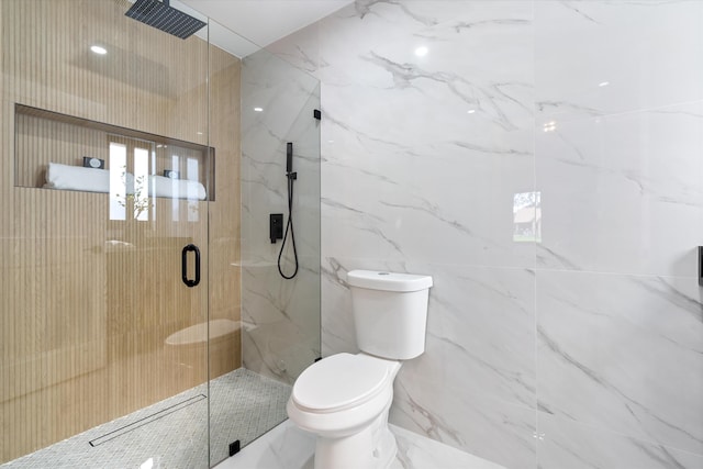 bathroom featuring a shower with shower door and toilet