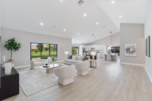 living room featuring high vaulted ceiling and light wood-type flooring