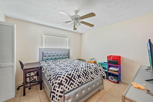 tiled bedroom with ceiling fan and a textured ceiling