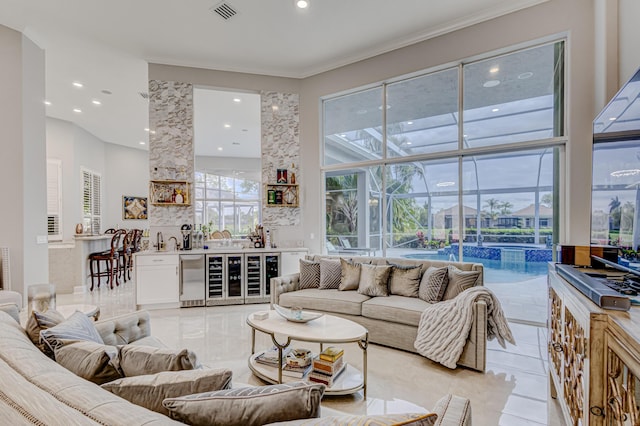 tiled living room featuring wine cooler, a high ceiling, bar, and ornamental molding