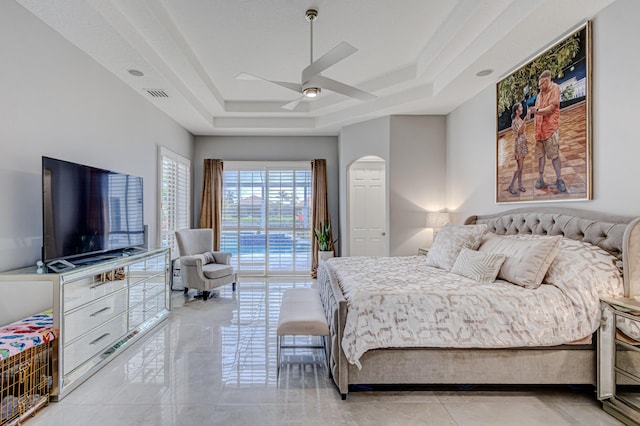 bedroom with ceiling fan and a raised ceiling