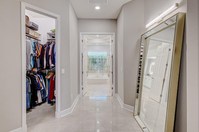 hall with light tile patterned floors