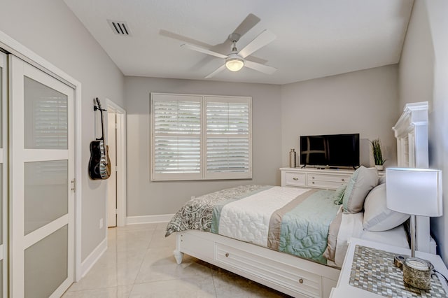 bedroom featuring ceiling fan, light tile patterned floors, and a closet