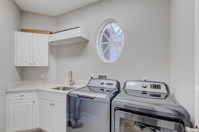 laundry room featuring washing machine and dryer, sink, and cabinets