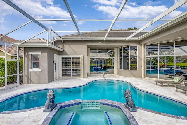 view of pool featuring an in ground hot tub, a lanai, and a patio