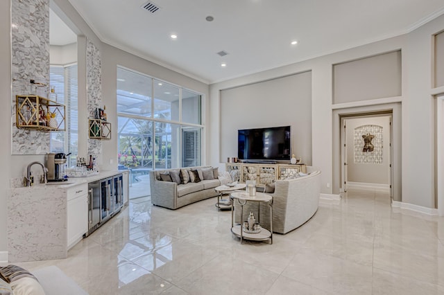 living room with sink, ornamental molding, and wine cooler