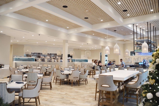 dining space featuring wood ceiling, beamed ceiling, and light hardwood / wood-style flooring