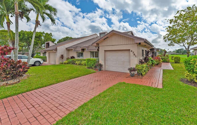 ranch-style house featuring decorative driveway, an attached garage, and a front yard