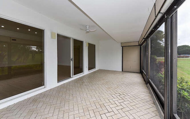 unfurnished sunroom with ceiling fan