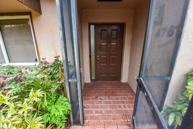 view of exterior entry featuring stucco siding