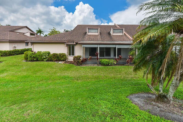 rear view of property with a lawn