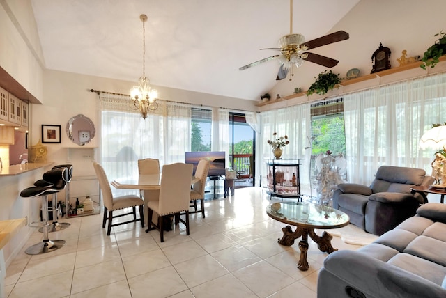 tiled dining space featuring ceiling fan with notable chandelier, vaulted ceiling, and a healthy amount of sunlight