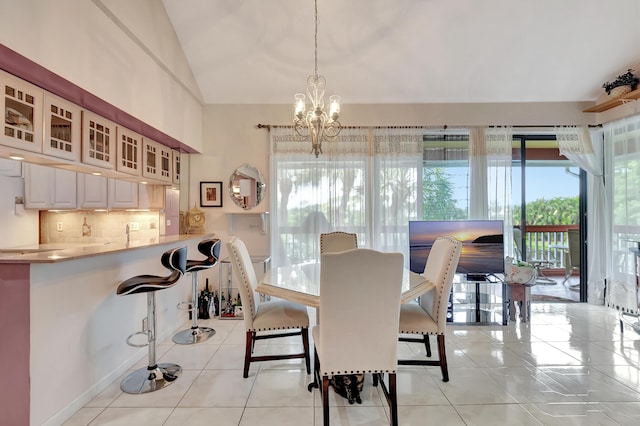 dining area with vaulted ceiling, light tile patterned flooring, and a chandelier