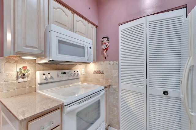 kitchen featuring white cabinets and white appliances