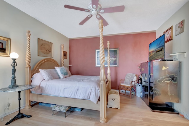 bedroom featuring ceiling fan, a textured ceiling, and light wood-type flooring