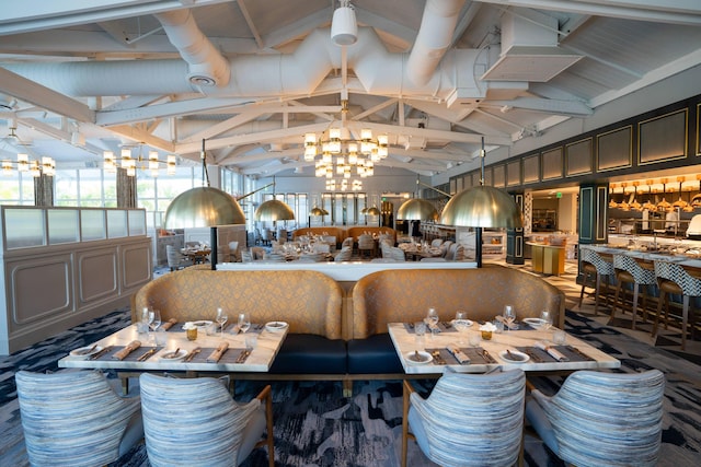 dining area with vaulted ceiling with beams and a chandelier