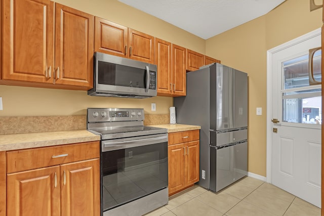 kitchen featuring stainless steel appliances and light tile patterned flooring