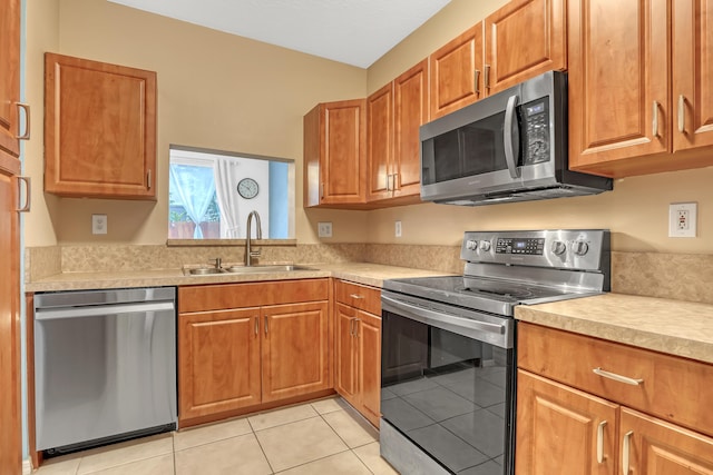 kitchen featuring stainless steel appliances, light tile patterned floors, and sink