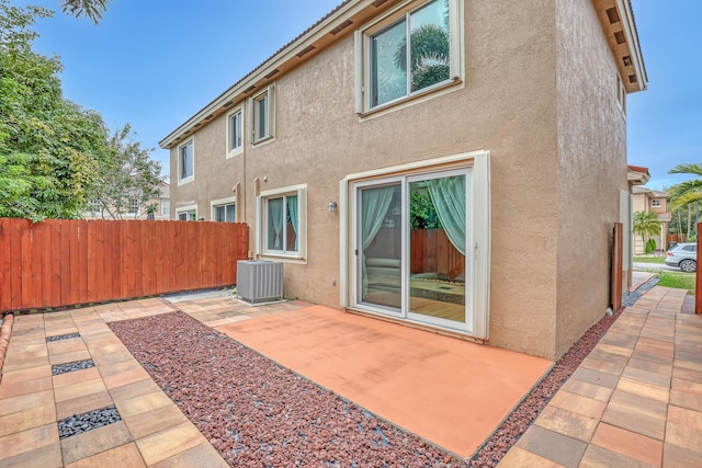 rear view of house with central AC and a patio