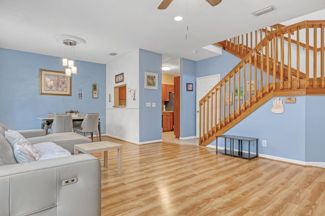 living room featuring ceiling fan and light hardwood / wood-style flooring