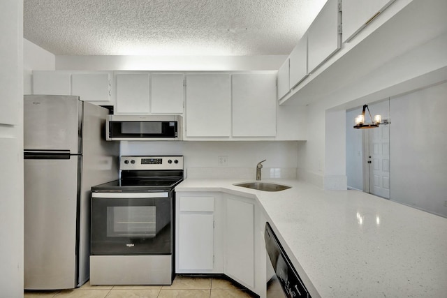 kitchen with white cabinetry, sink, appliances with stainless steel finishes, and a chandelier