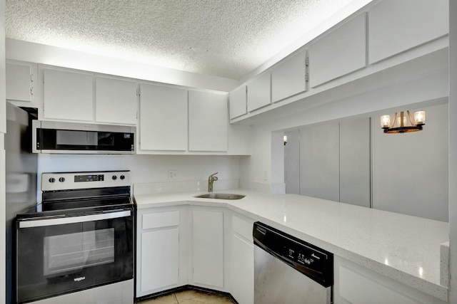 kitchen with sink, stainless steel appliances, light tile patterned flooring, a textured ceiling, and white cabinets