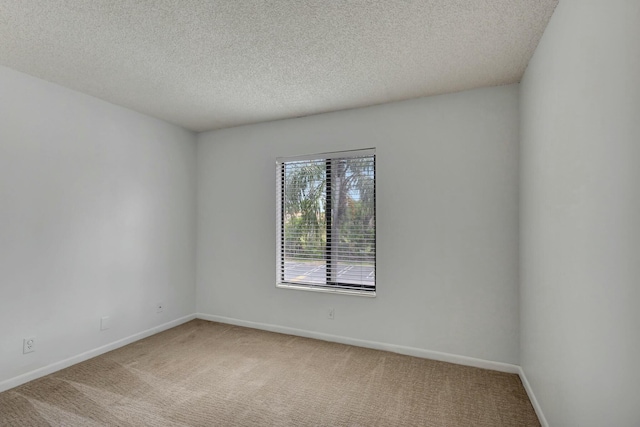 unfurnished room with carpet and a textured ceiling