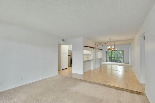 tiled empty room featuring a notable chandelier